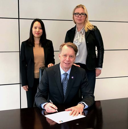 Photograph of Peter Lukasiewicz, CEO of Gowling WLG Canada, signs the Accord alongside energy partner Irene Choe and energy associate Magda Hanebach.